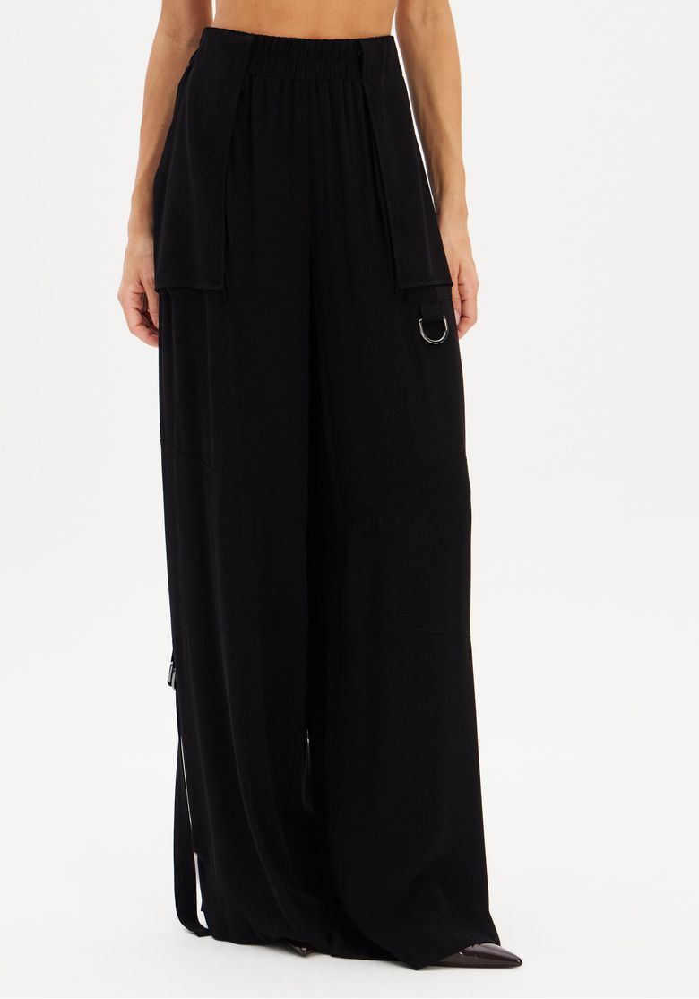 Detalhe frontal da calça wide leg preta com recorte na perna e bolso lateral tipo patch com argola decorativa