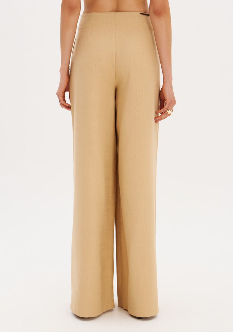 Close da cintura da calça wide leg bege destacando o cinto embutido, pregas frontais e abertura dos bolsos laterais embutidos