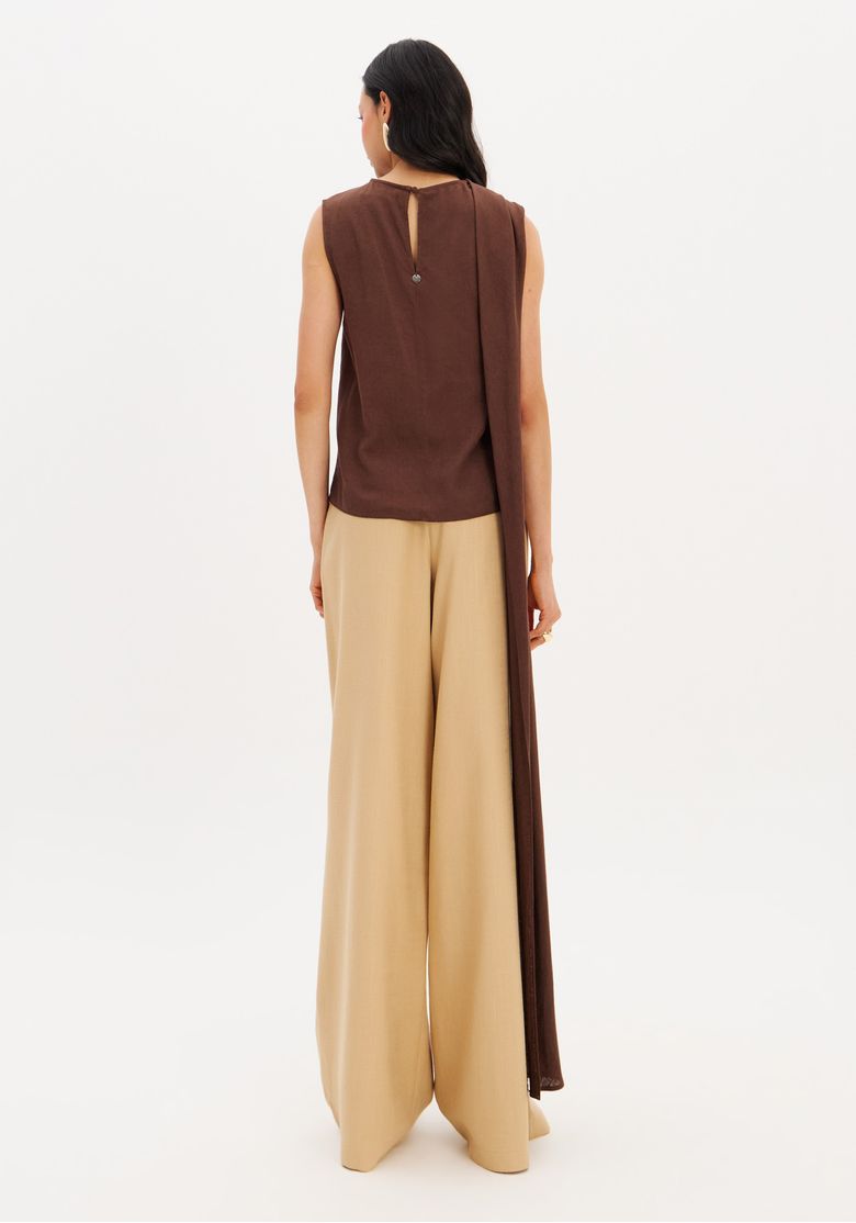 Vista posterior completa do look com calça wide leg bege e top marrom, mostrando o comprimento longo e o caimento amplo da peça