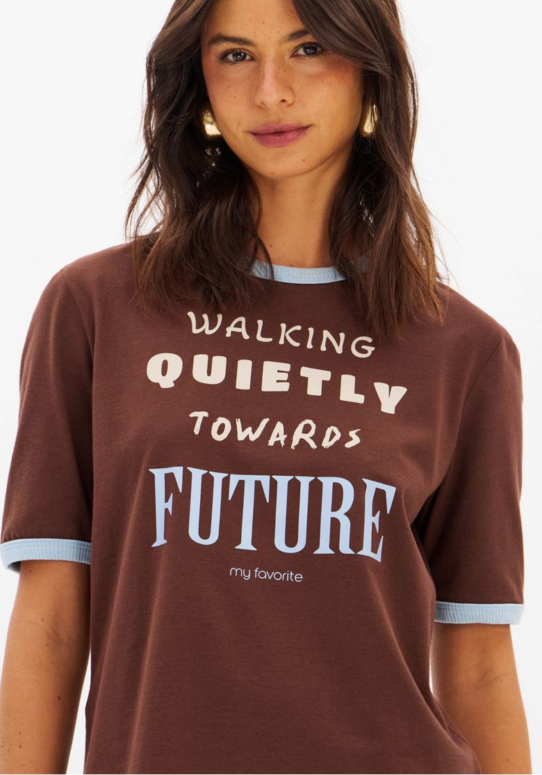 Detalhe da estampa frontal da camiseta marrom com frase estilosa.