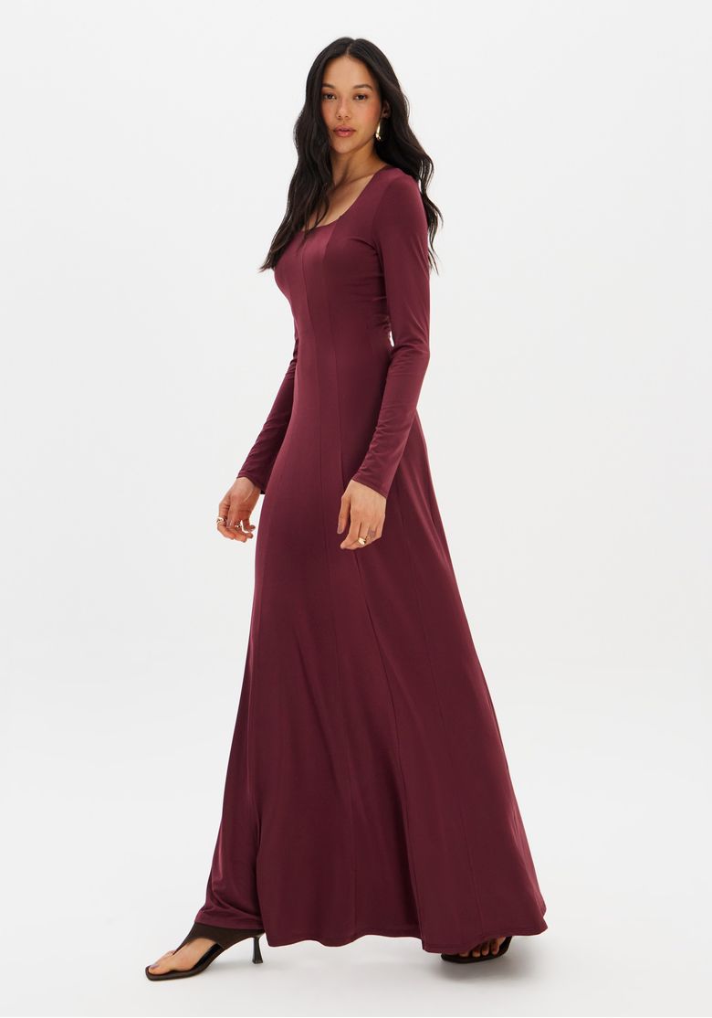 Close no torso do vestido bordô evidenciando tecido em malha pesada e costuras longitudinais