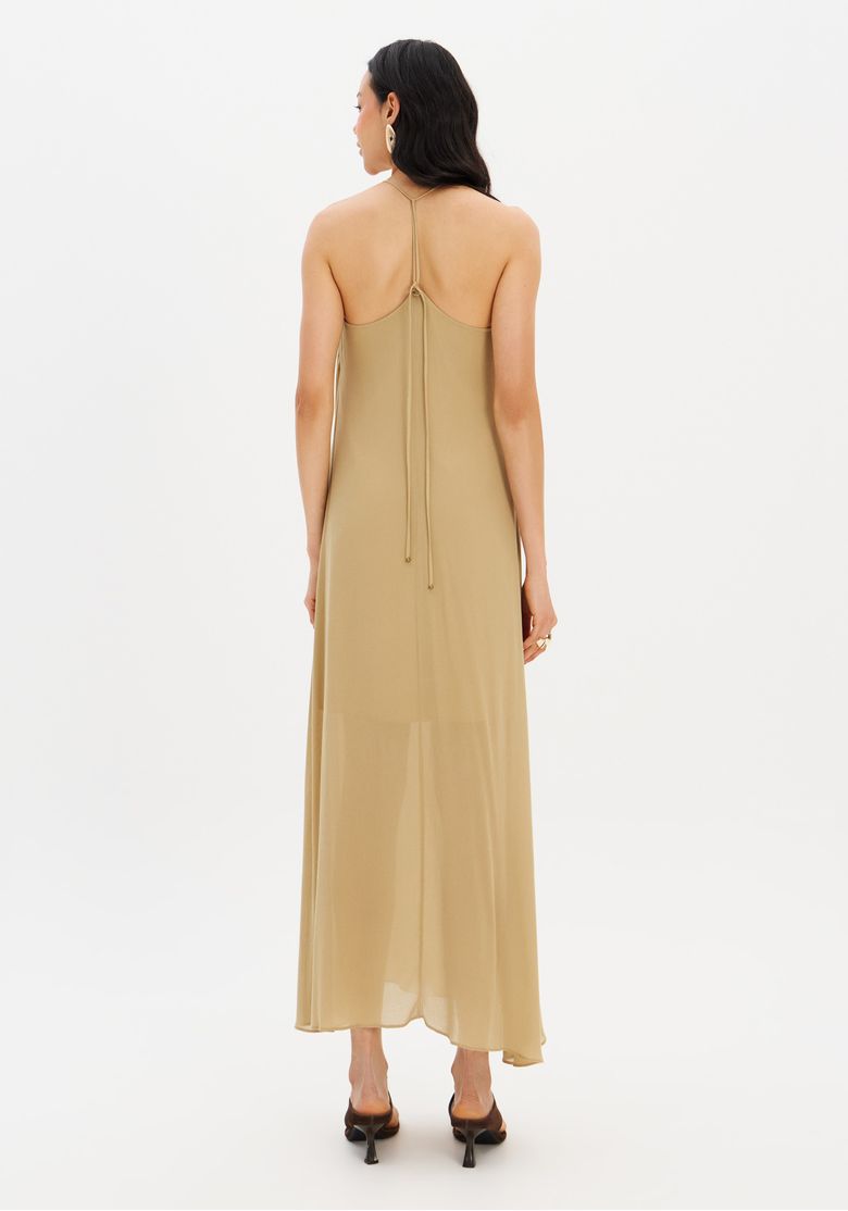 Vista traseira do vestido super midi bege, evidenciando a amarração nas costas.