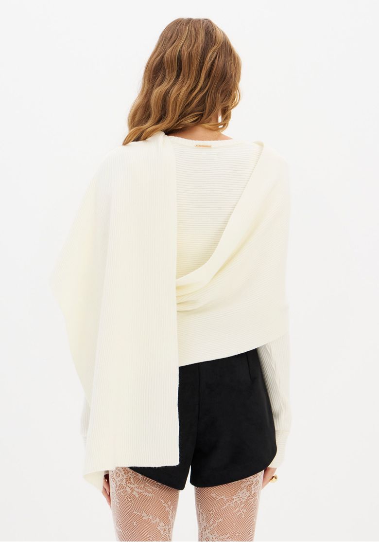 Close frontal da blusa de tricô branca com sobreposição assimétrica, detalhe da malha canelada e decote redondo