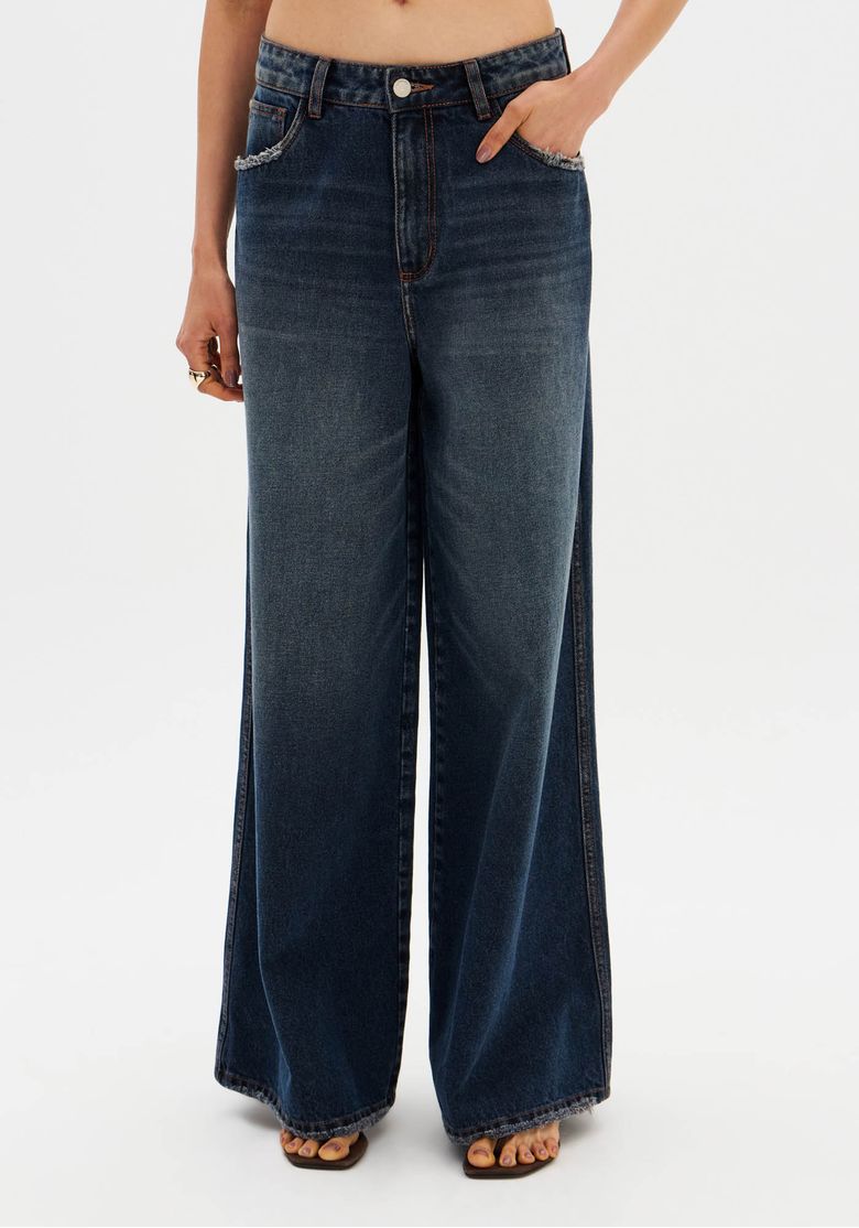Detalhe frontal da calça jeans palazzo azul, mostrando cintura média e bolsos embutidos.