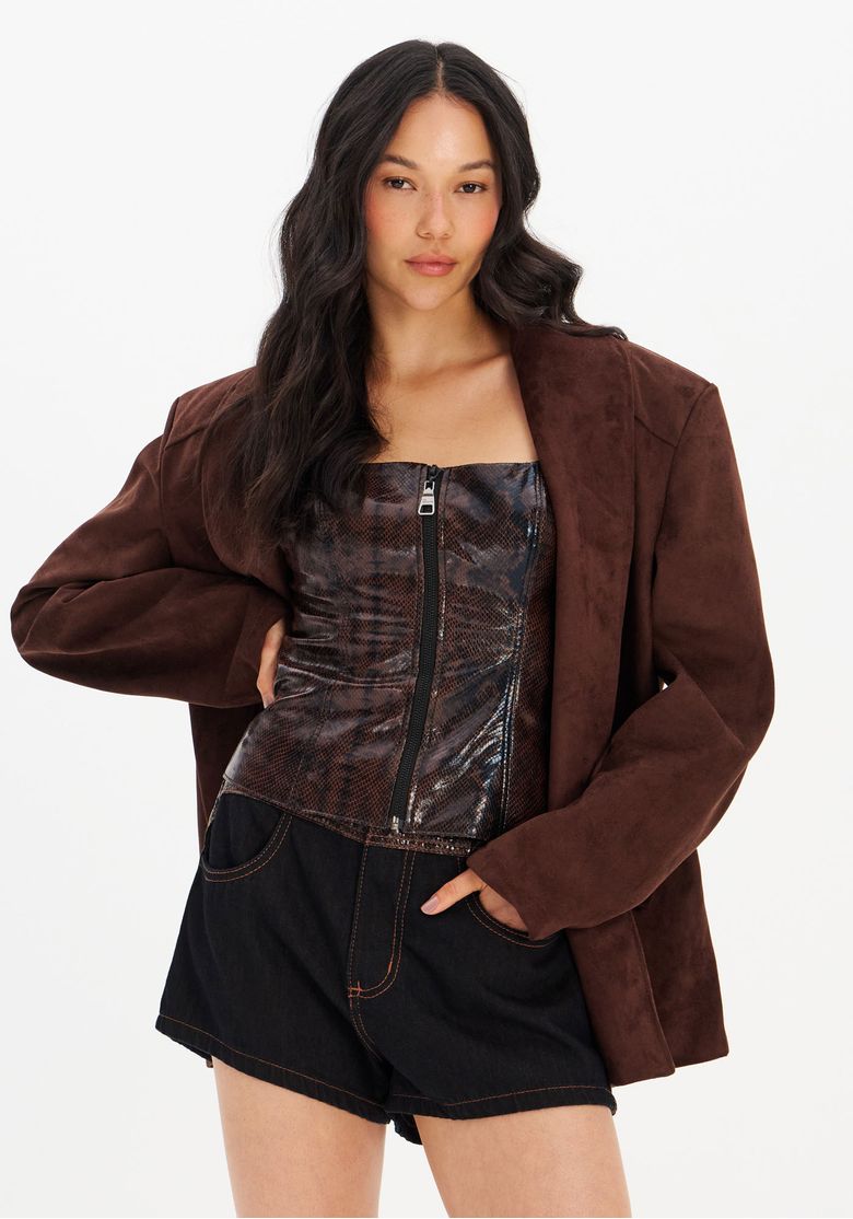 Modelo vestindo short jeans tridimensional causando o ajuste elegante. Blusa e blazer distintivos complementam a aparência especial.