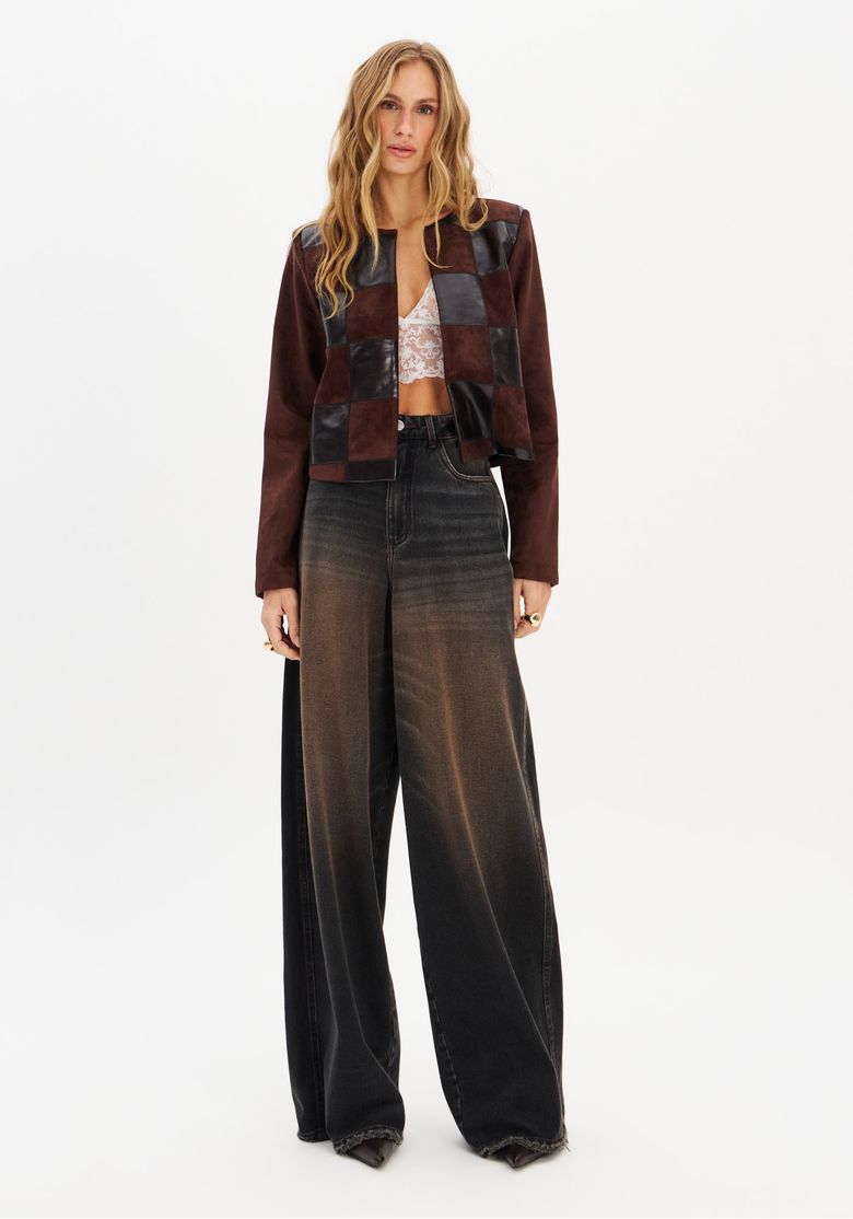 Close frontal: detalhe do bordado patchwork mostrando quadrados alternados em PU brilhante e suede texturizado, costura artesanal e gola padre sem fechamento