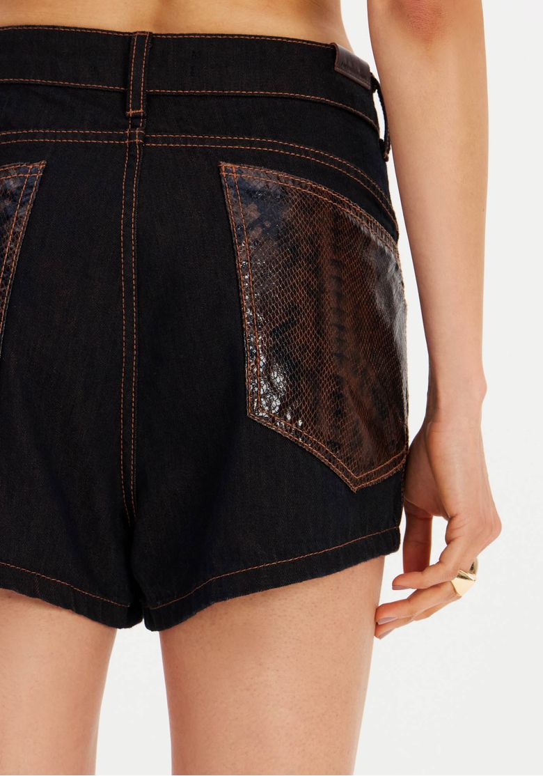 Zoom nos detalhes do bolso e acabamento do short em tecidos premium.