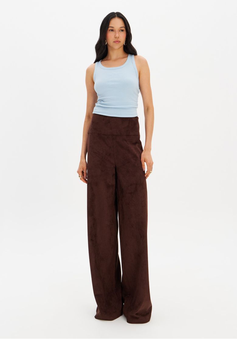 Modelo vestindo blusa regata canelada azul claro com calça marrom, vista frontal.