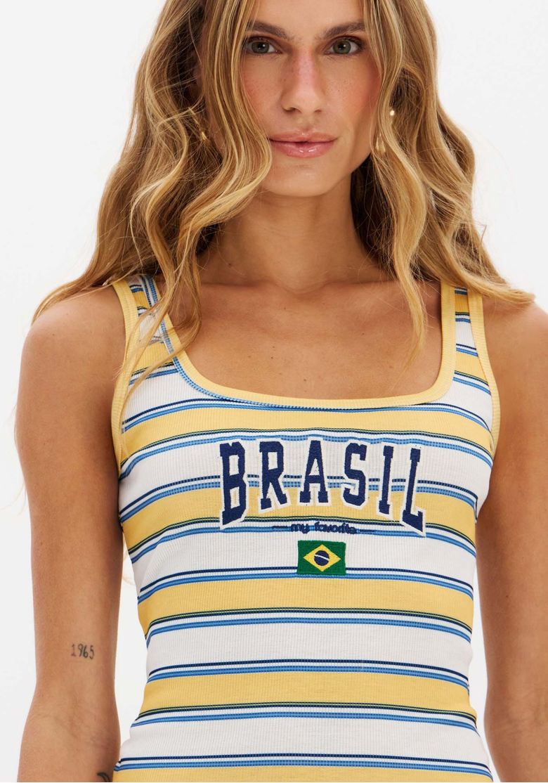 Modelo em pé usando regata canelada listrada com calça jeans wide leg, look casual urbano da tendência brazil core