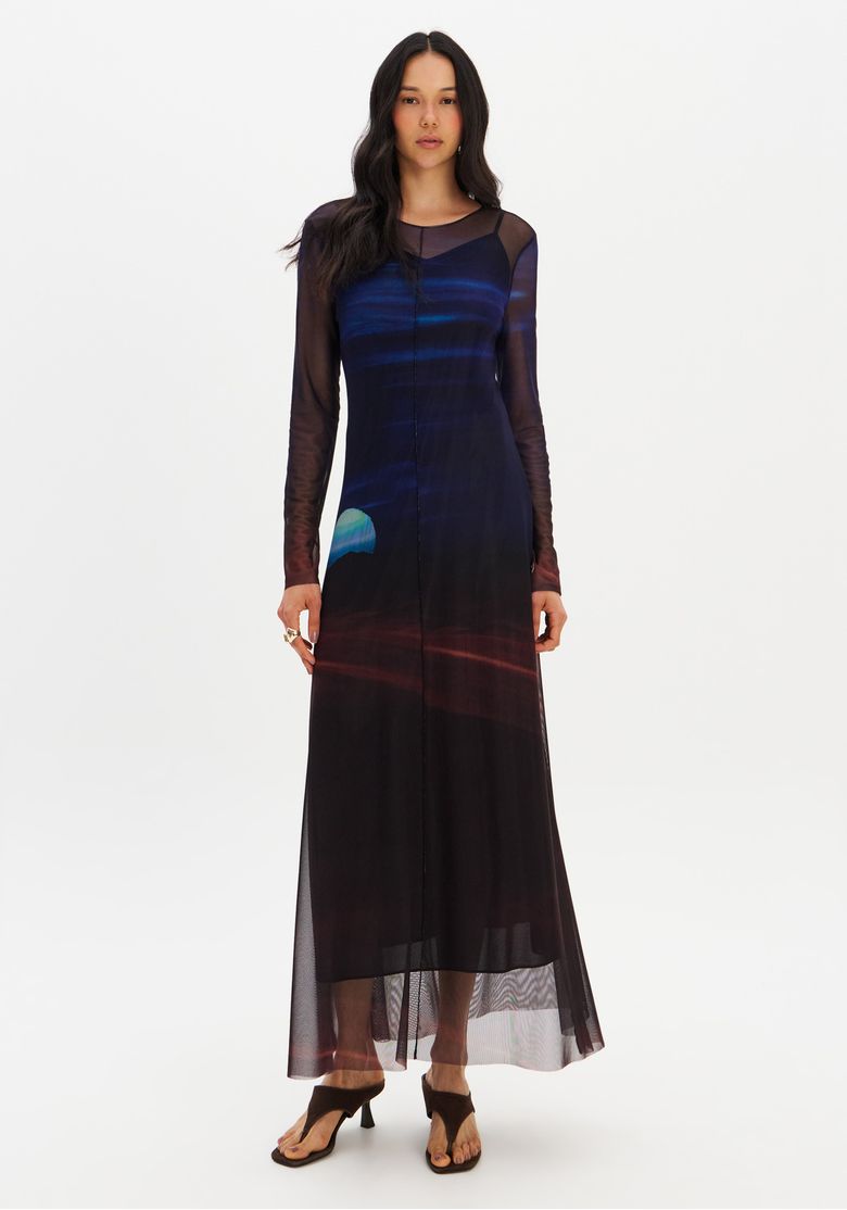 Vestido super midi com mangas longas em tecido de tule, exibido em um ambiente interno.