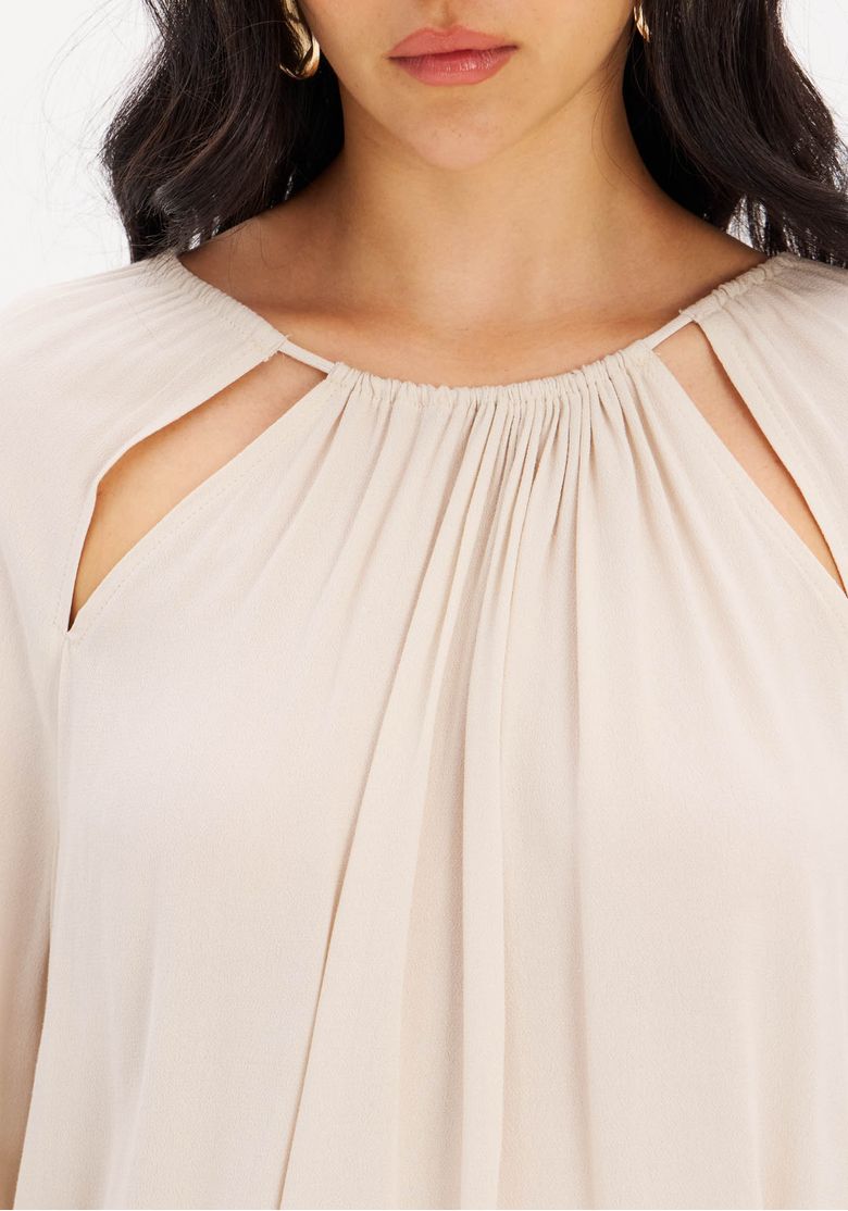 Close-up-do-decote-com-recortes-do-vestido-curto-em-crepe.