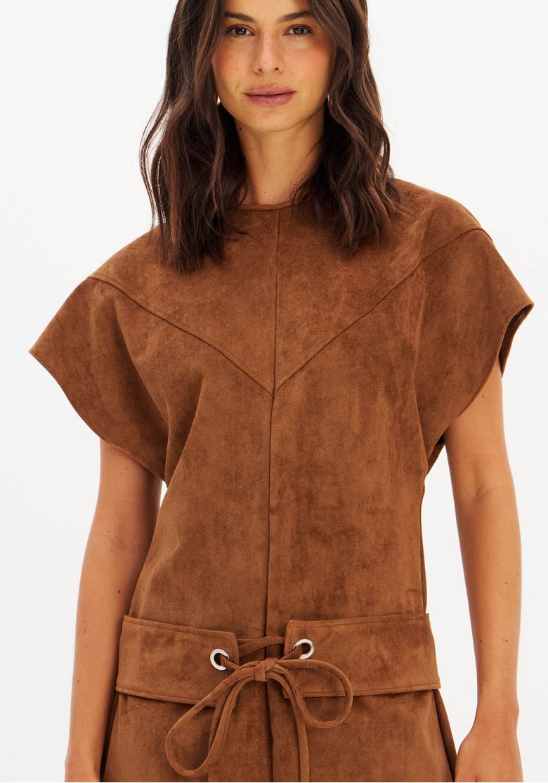 Close-up-do-busto-do-vestido-suede-marrom-mostrando-decote-redondo-e-recortes-geometricos-no-corpo
