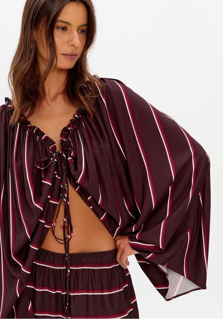 Detalhe do ajuste frontal da blusa ampla listrada.
