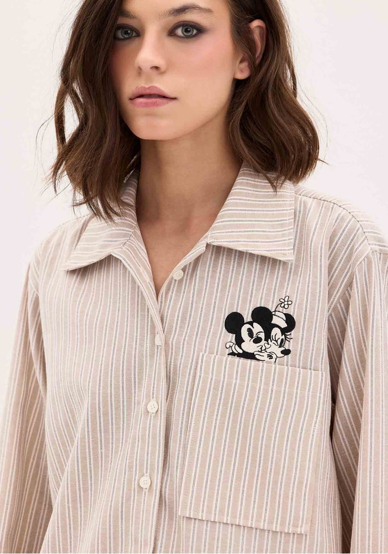 Close-up do bordado do Mickey na camisa feminina Disney com listras bege.