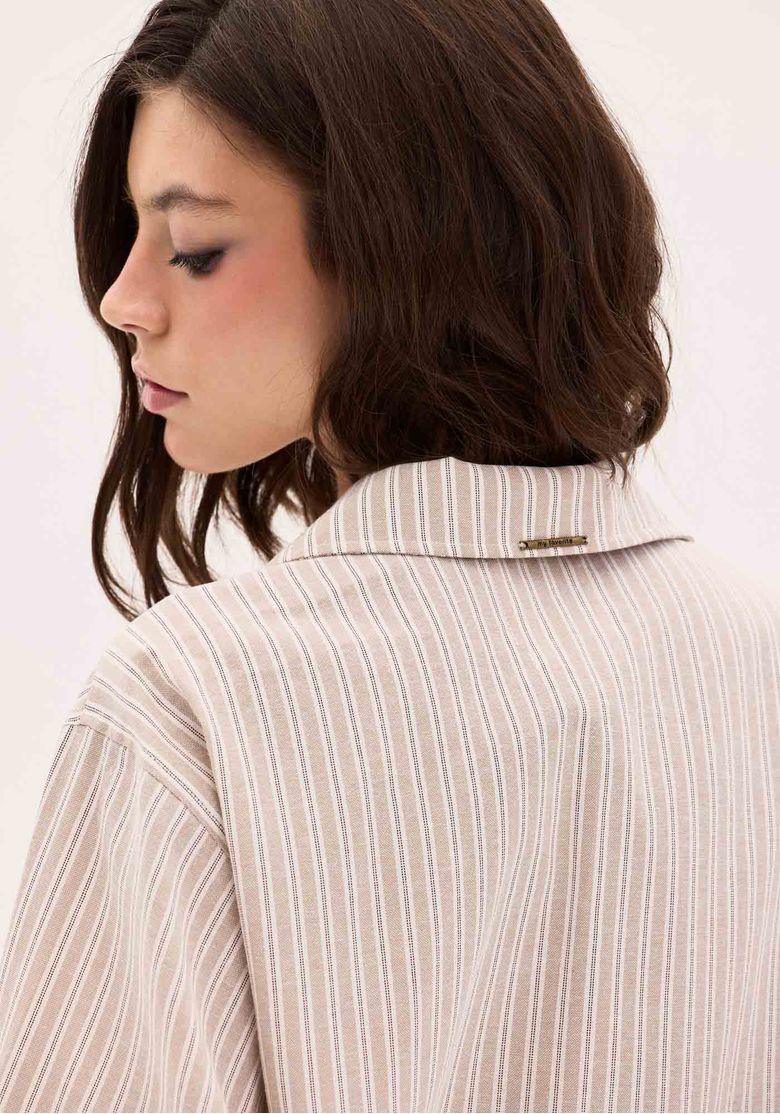 Close-up da gola de lapela da camisa feminina Disney com listras bege.