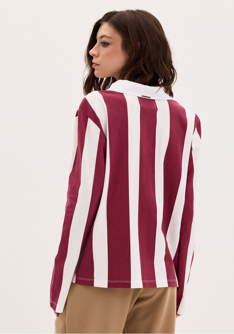 Vista traseira da camiseta listrada mostrando ombro levemente deslocado e comprimento alongado.