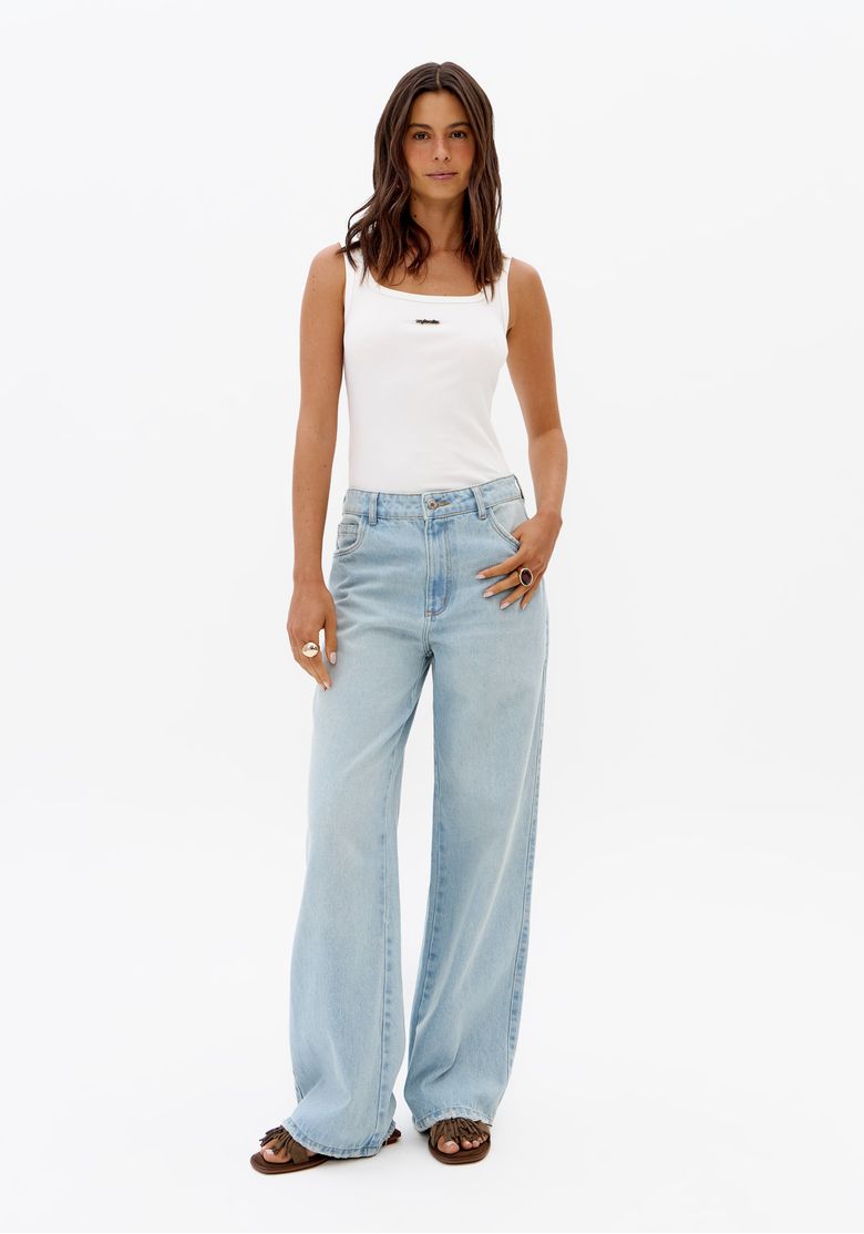 Modelo usando calça jeans feminina azul clara full length de cintura média com caimento reto e top branco em fundo neutro