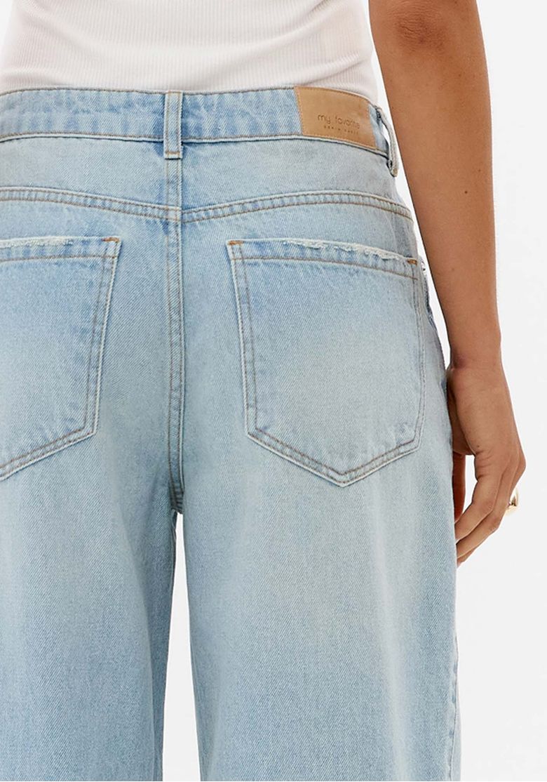 Close nas costas da calça jeans azul clara feminina mostrando bolsos traseiros, cós com passantes e lavagem clara