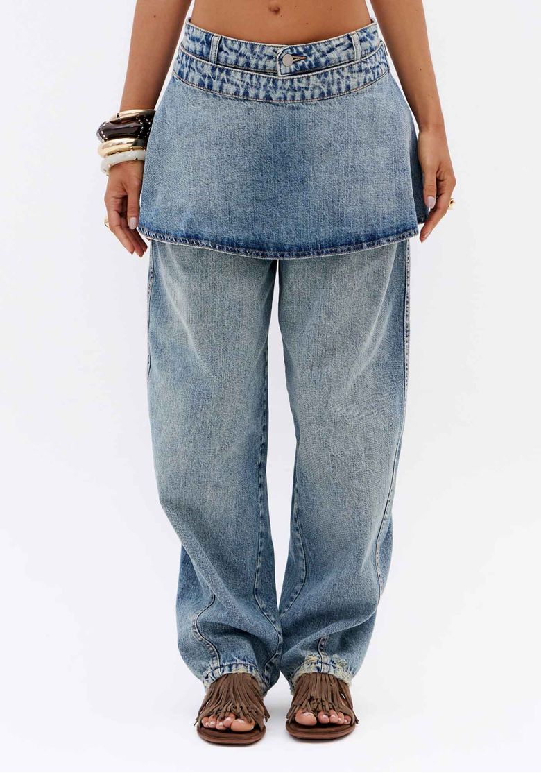Close frontal de calça jeans carrot azul com saia sobreposta removível, cintura média e barra longa em denim feminino
