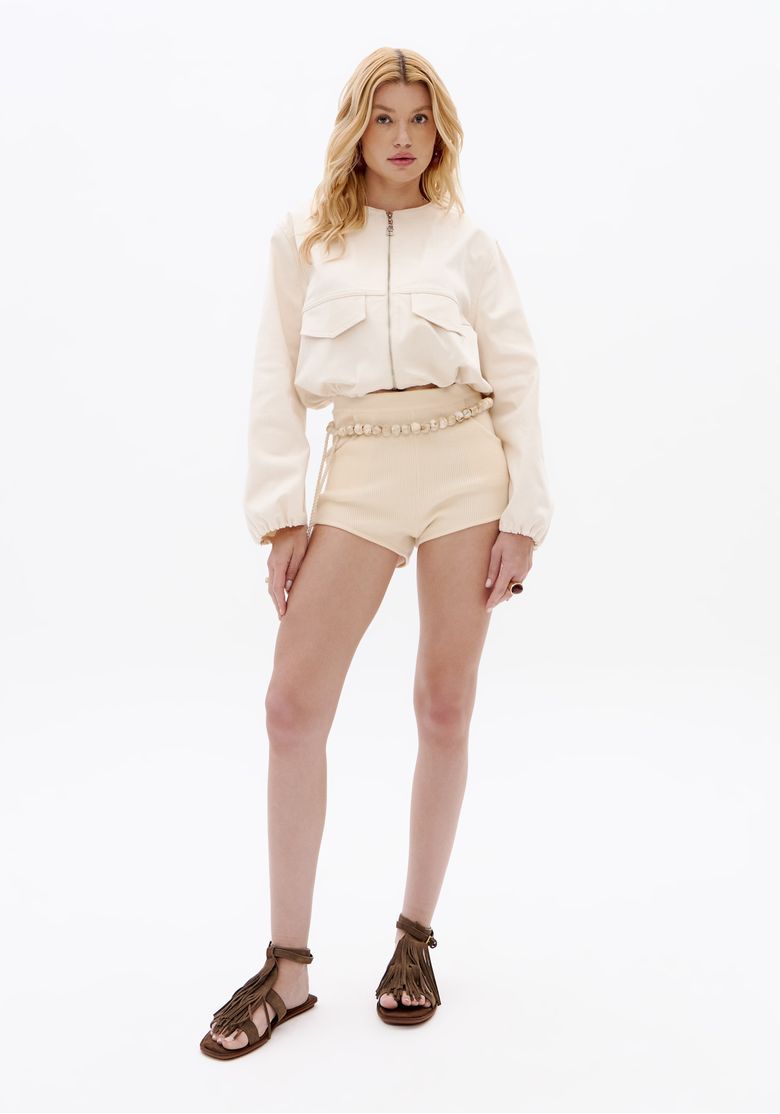 Look completo com jaqueta de sarja balloon bordada off white, shorts claros de cintura alta e sandália rasteira marrom