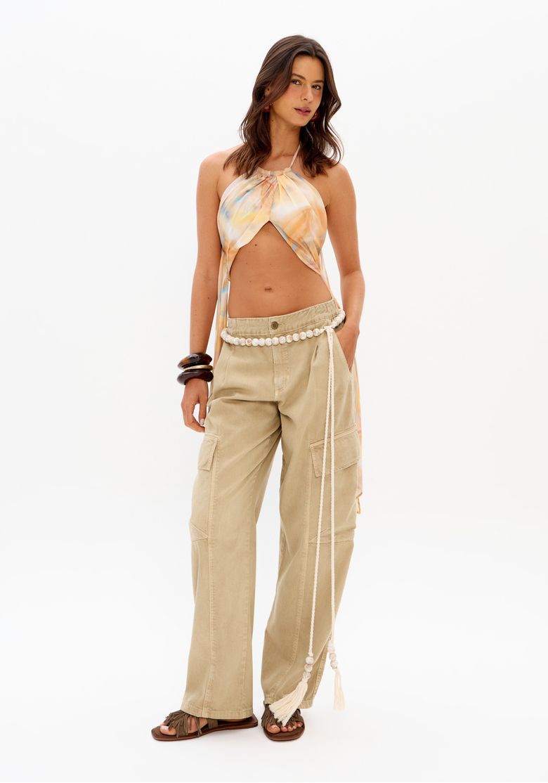 Vista frontal do look com blusa cropped estampada frente única e calça cargo bege feminina
