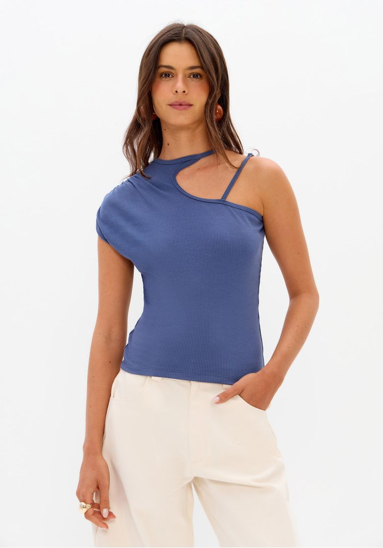 Modelo usando blusa canelada azul ombro único feminina com recorte vazado no decote e calça clara em foto frontal