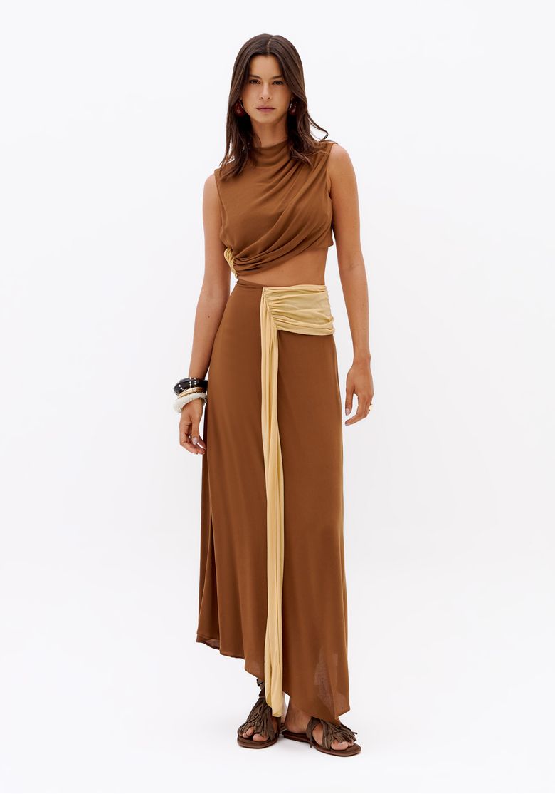 Vestido super midi assimétrico feminino em estúdio, com faixa contrastante na cintura, modelagem fluida e sandália rasteira
