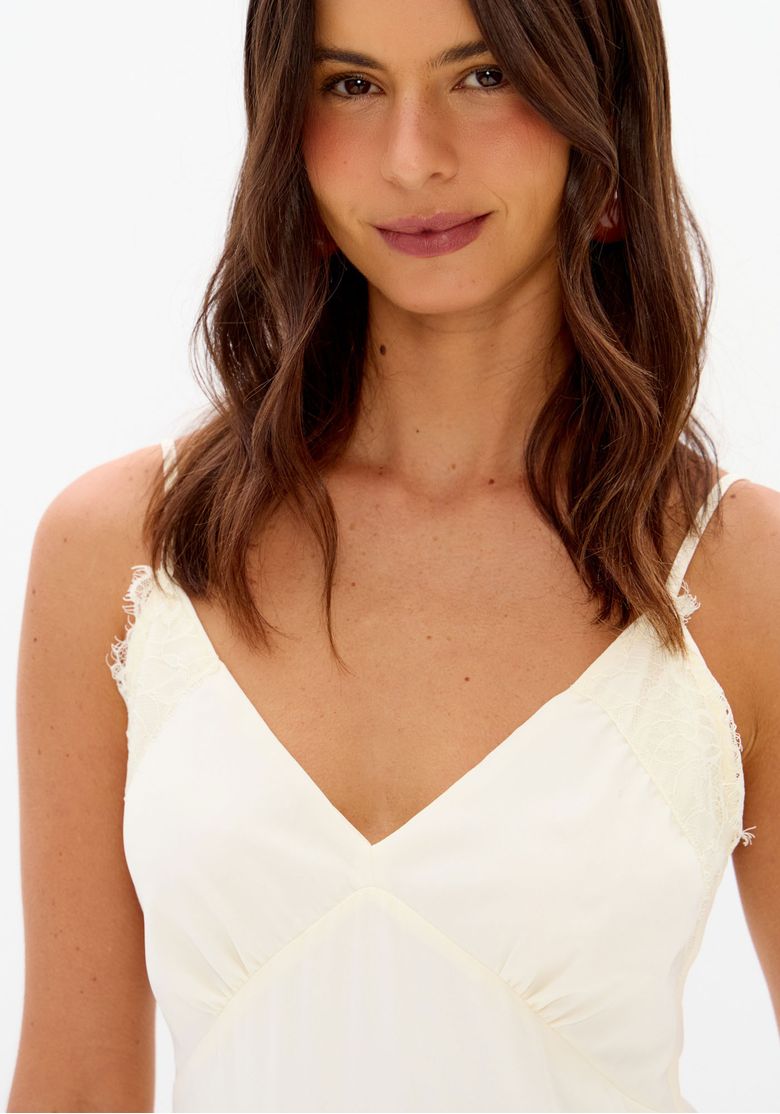 Close do busto do vestido off white com decote V, franzido e alças finas com acabamento delicado