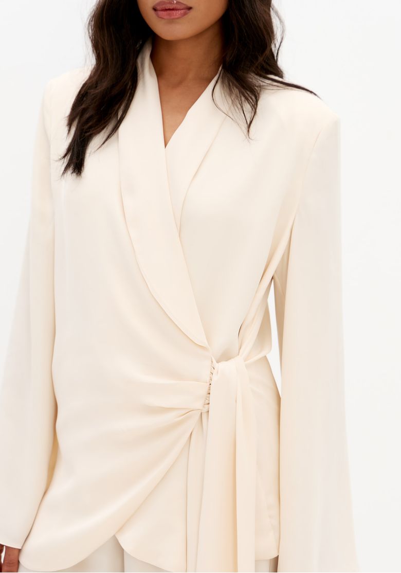 Detalhe-do-blazer-de-cetim-off-white-com-transpasse-frontal-e-amarracao-lateral-drapeada