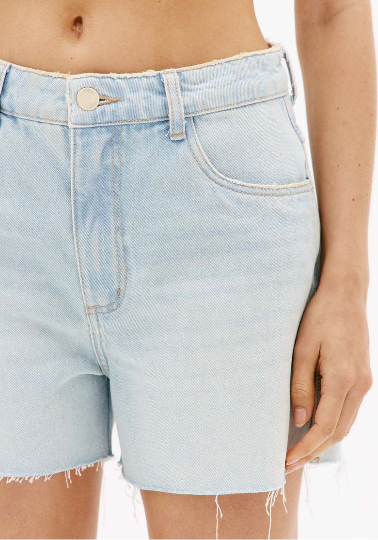 Close-do-cos-do-short-jeans-azul-claro-com-botao-frontal-passantes-bolso-frontal-e-acabamento-desfiado-na-barra