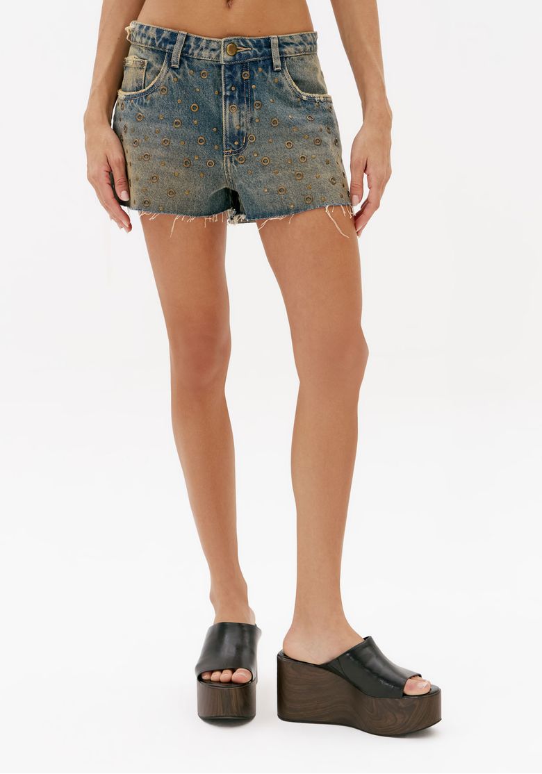 Vista frontal do short jeans azul curto com modelagem relaxed, aplicações metálicas e acabamento desfiado na barra