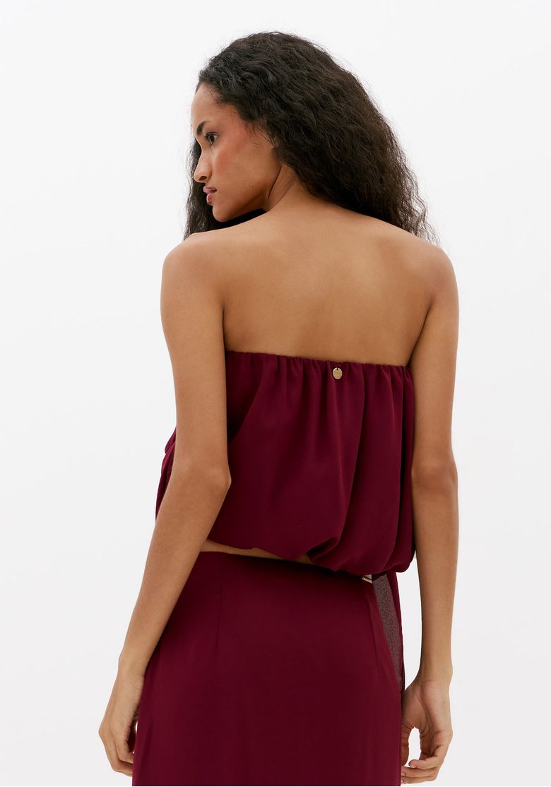 Vista-traseira-de-blusa-cropped-bordo-sem-manga-com-caimento-solto-e-elastico-nas-costas