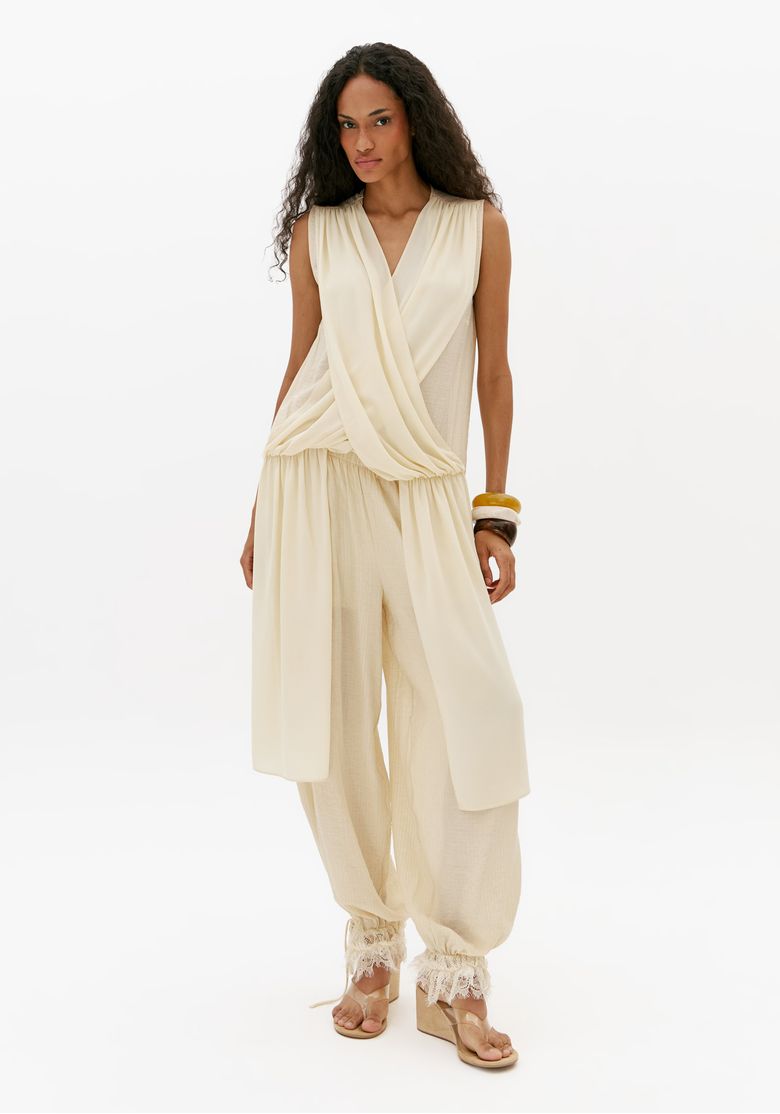 Look-feminino-com-blusa-assimetrica-off-white-sem-mangas-e-calca-ampla-off-white-visual-completo-elegante