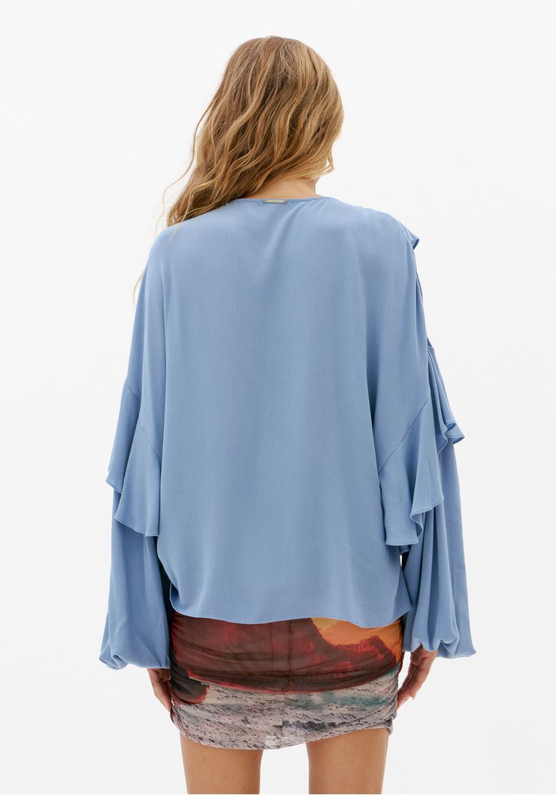 Vista traseira da blusa bata azul feminina com caimento fluido, manga longa ampla e barra arredondada