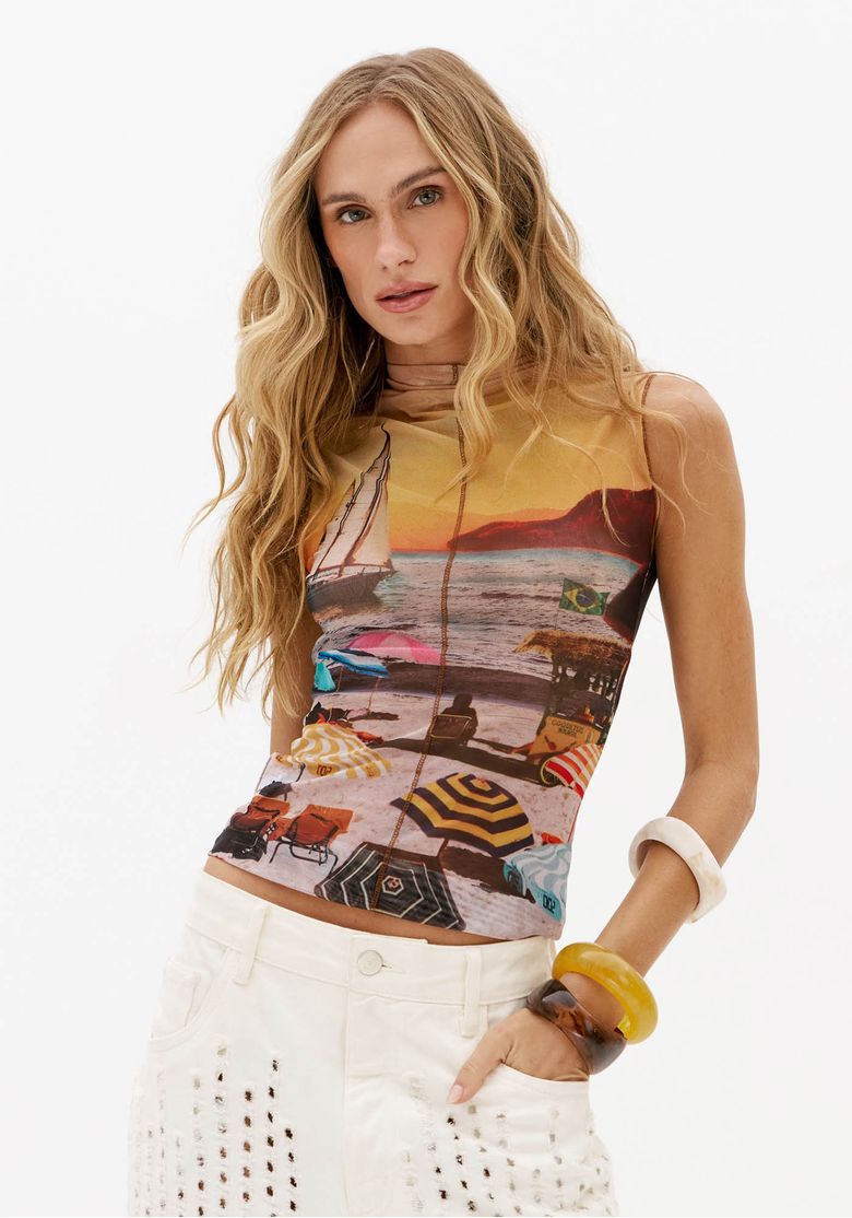 Blusa feminina estampada de tule com gola alta e caimento ajustado, vista frontal lateral com estampa de praia multicolorida