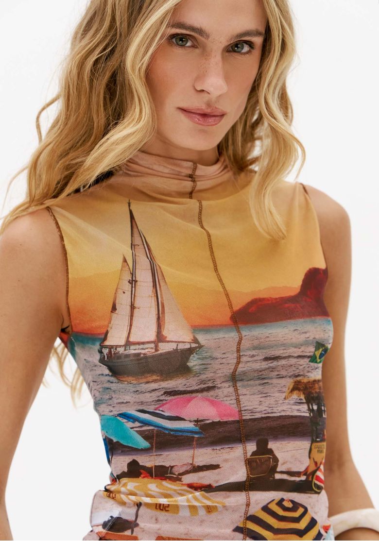 Close da blusa sem manga gola alta de tule estampada, detalhe da estampa de paisagem de praia e ajuste ao corpo