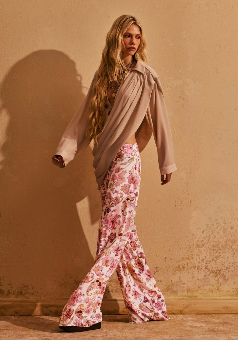 Modelo-usando-calca-feminina-full-length-estampada-floral-e-paisley-branca-com-blusa-fluida-clara-em-look-elegante