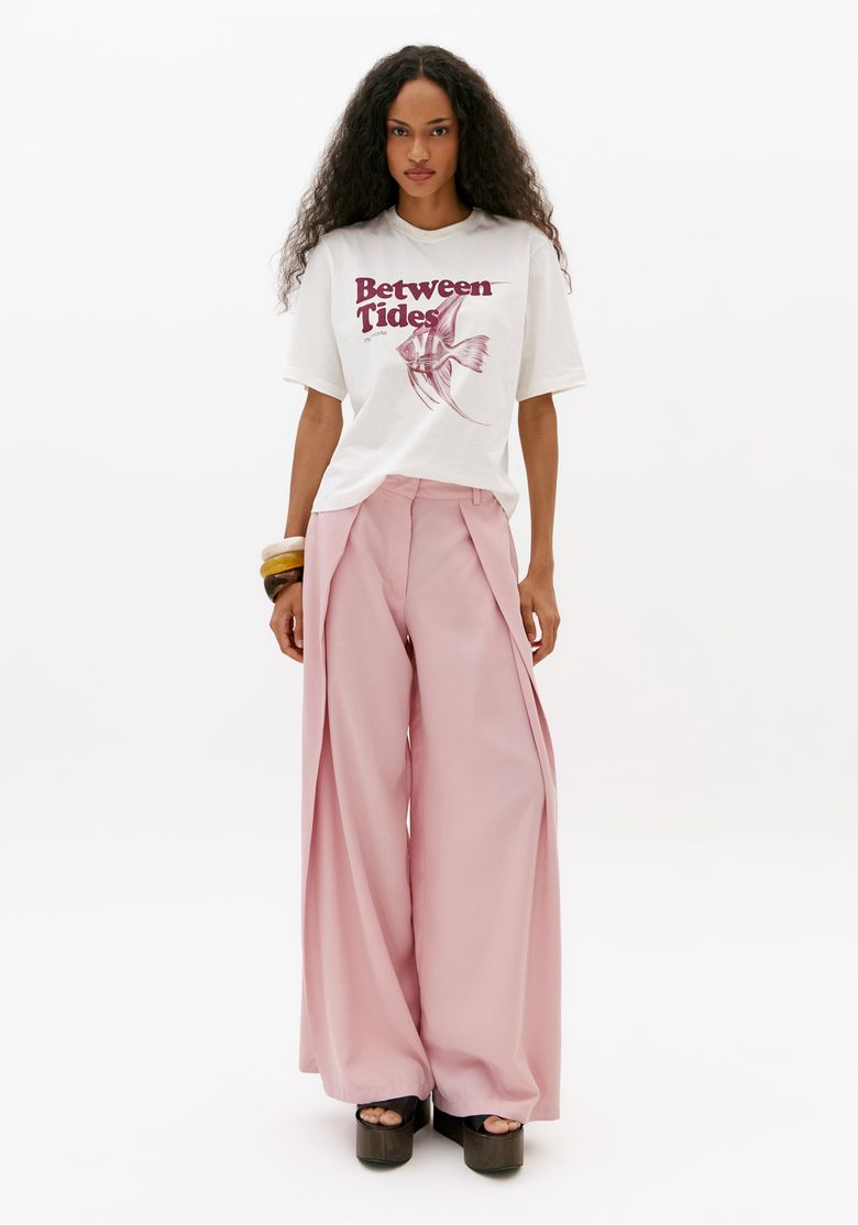 Modelo-usando-calca-barrel-rosa-de-cintura-media-com-recortes-frontais-e-camiseta-branca-estampada-em-look-feminino-moderno