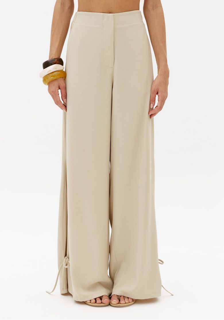 Vista frontal da calça barrel off white feminina com modelagem ampla, cintura média e barra longa com detalhe de amarração lateral