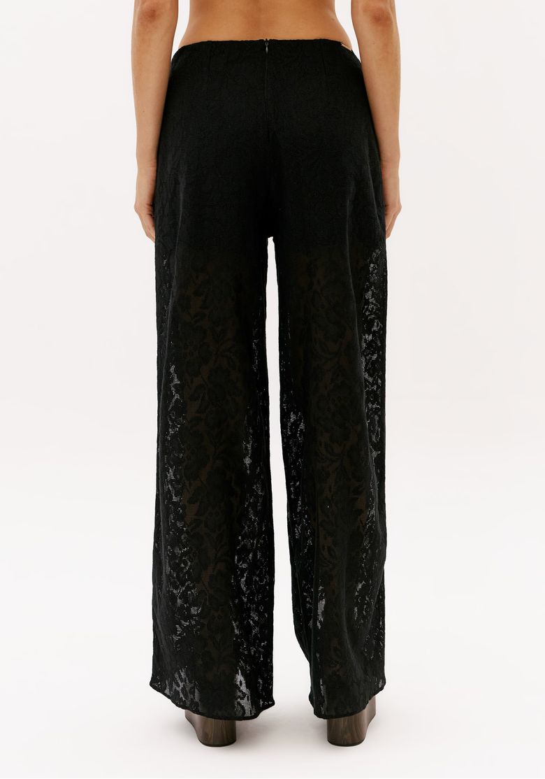 Look com calça feminina de renda preta wide leg full length usada com top preto e sandália plataforma