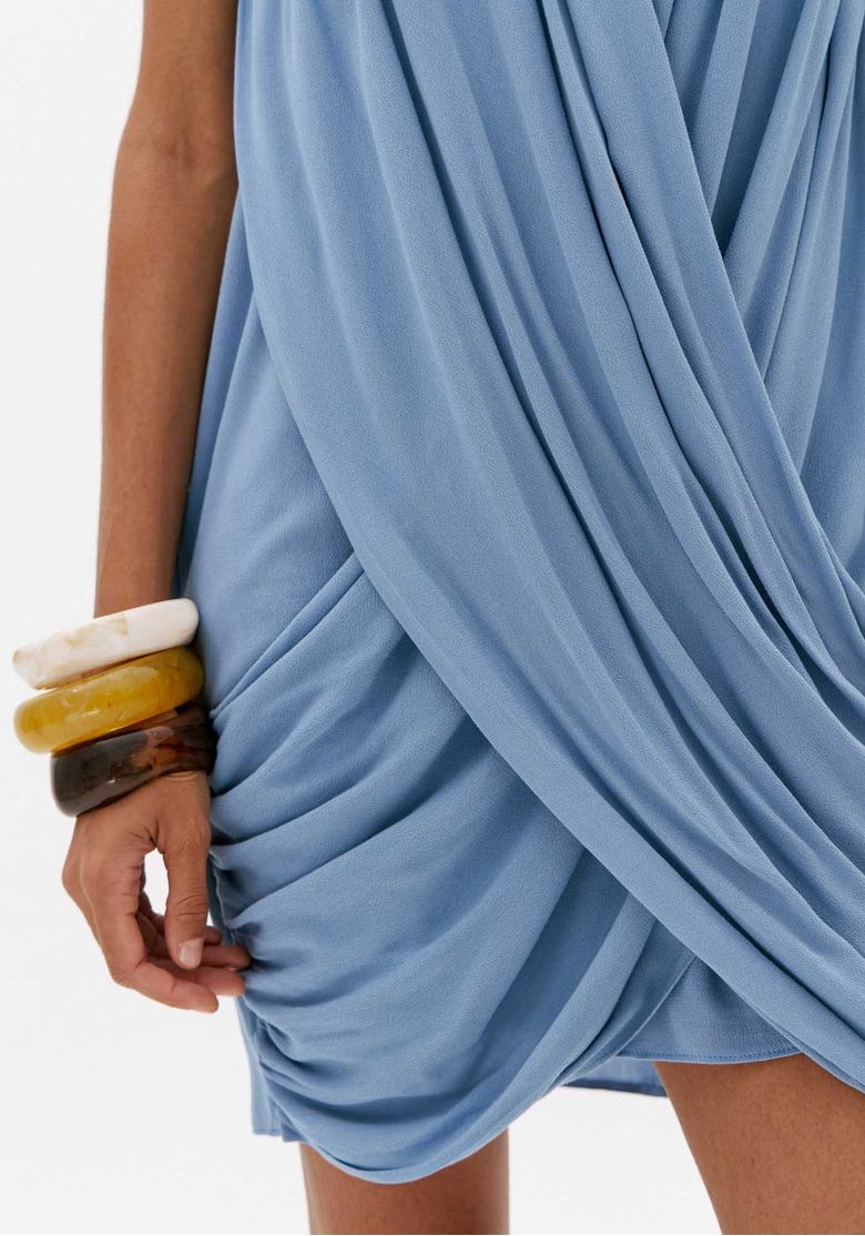 Close do tecido azul claro com franzidos e drapeado na barra de vestido curto feminino