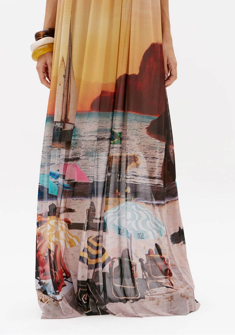 Detalhe da barra do vestido longo de tule estampado com paisagem de praia, efeito degradê e caimento fluido