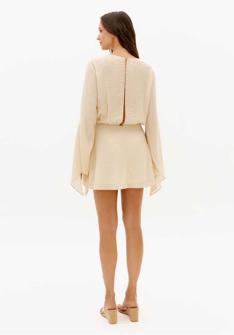 Vista traseira do vestido curto off white com abertura nas costas e mangas longas amplas