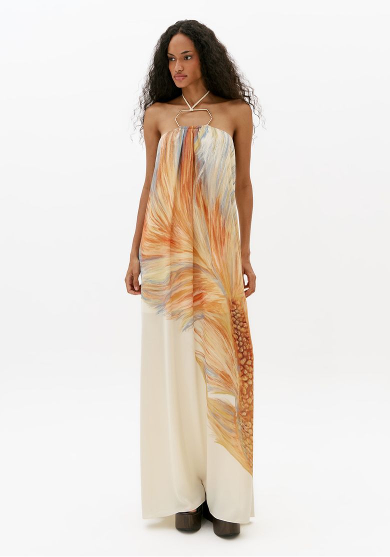 Modelo usando vestido longo frente única estampado branco com detalhe de metal e caimento fluido em foto de corpo inteiro