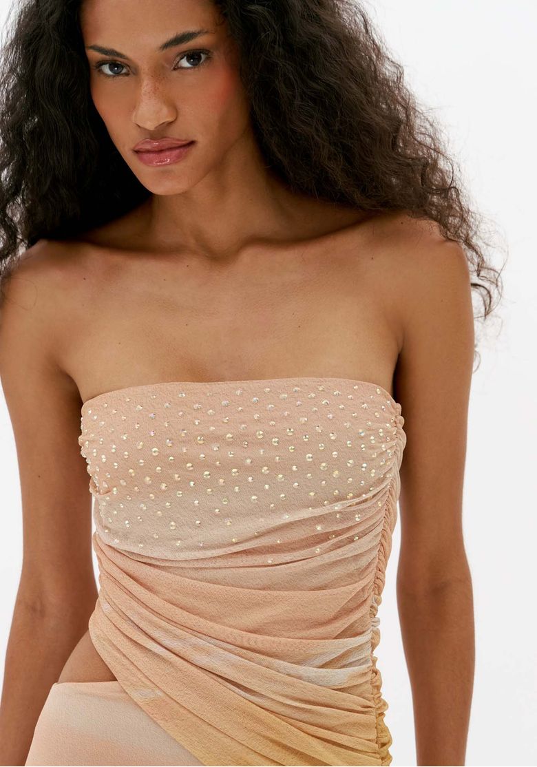 Close frontal do busto e cintura do vestido super midi de tule com brilho, mostrando aplicações brilhantes, decote reto e drapeado diagonal