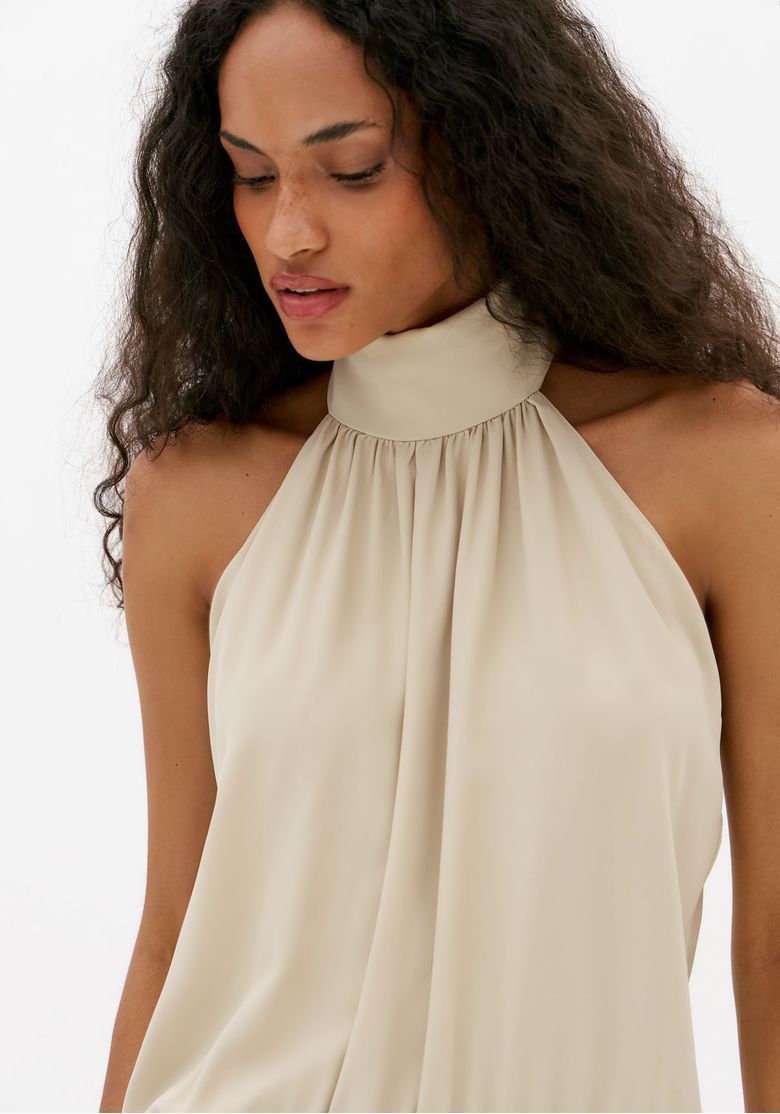 Detalhe do busto do vestido off white frente única com gola alta e caimento fluido elegante