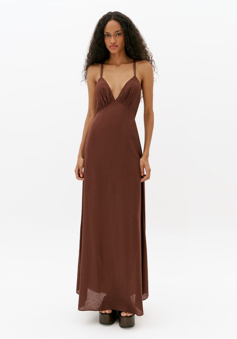 Modelo vestindo vestido longo marrom de alça fina com decote V profundo e caimento fluido em foto frontal