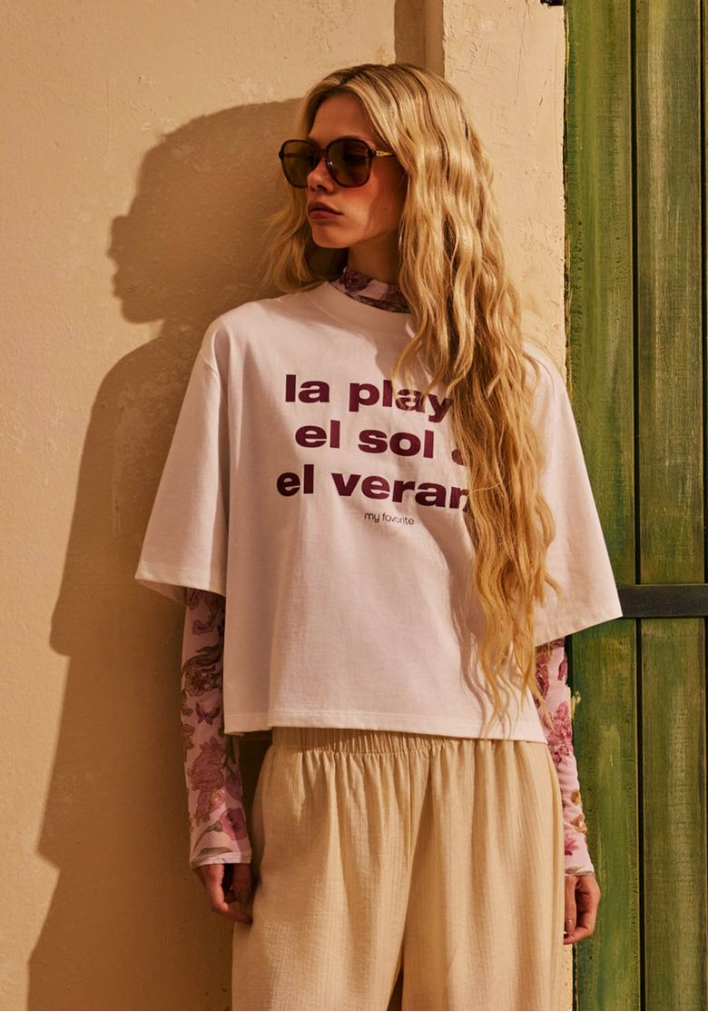 Modelo-usando-t-shirt-feminina-off-white-de-malha-com-estampa-tipografica-frontal-e-lenco-floral-em-look-casual-de-verao