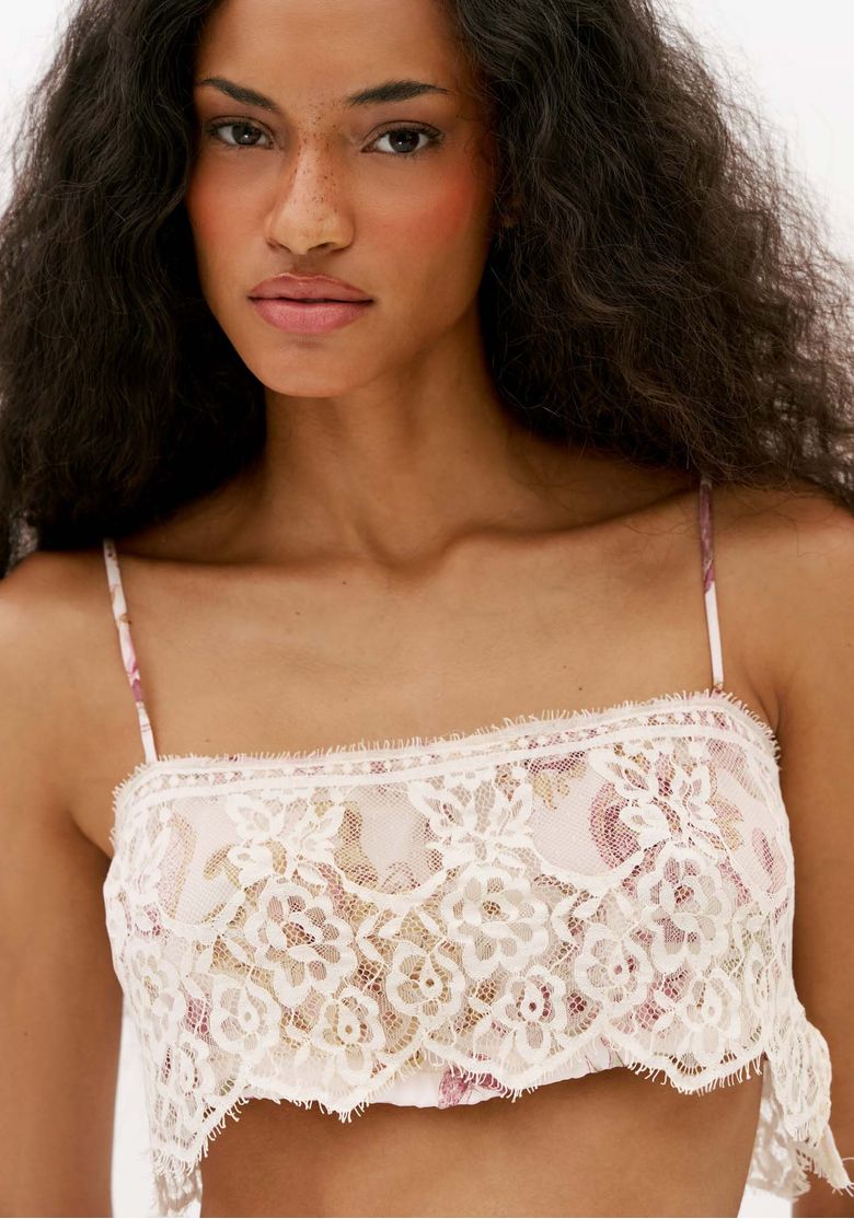 Close-do-top-de-alca-estampado-com-renda-branca-floral-mostrando-decote-reto-e-transparencia-delicada