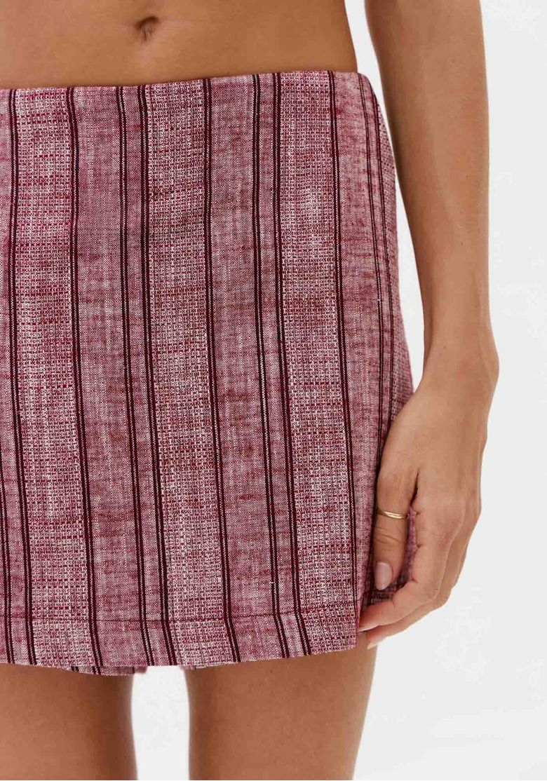 Close-frontal-do-short-saia-bordo-com-listras-verticais-em-tecido-leve-com-aparencia-de-saia